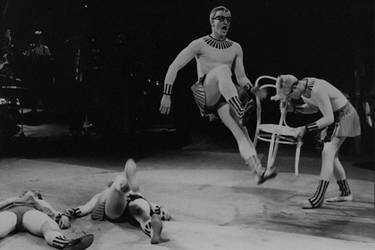 Production still for "Madame Mao". Alan Clarke (airborne, centre). Photographer: Ponch Hawkes