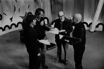 Production still for "The Virgin: Miracles at Christmas". Director Murray Copland (far right) talks through a scene with his actors. Photographer: Jeff Busby